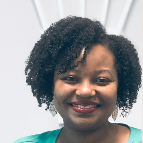 A woman with curly black hair smiles, wearing large earrings and a teal top, against a light background with soft lines.